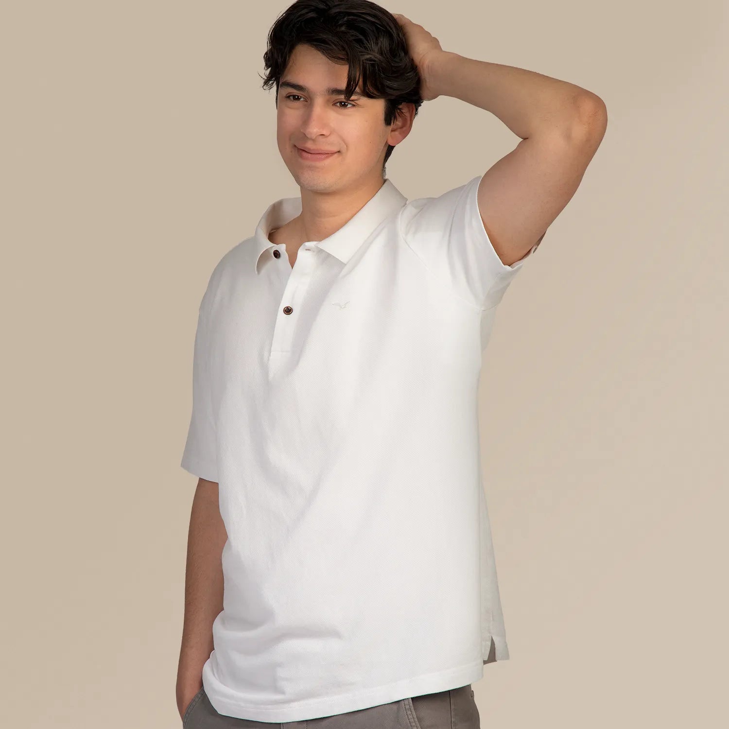 Studio Productfoto Mannelijk model met Anti Zweet Polo shirt Wit van ConfidenceForAll die zijn arm omhoog houdt diagonaal