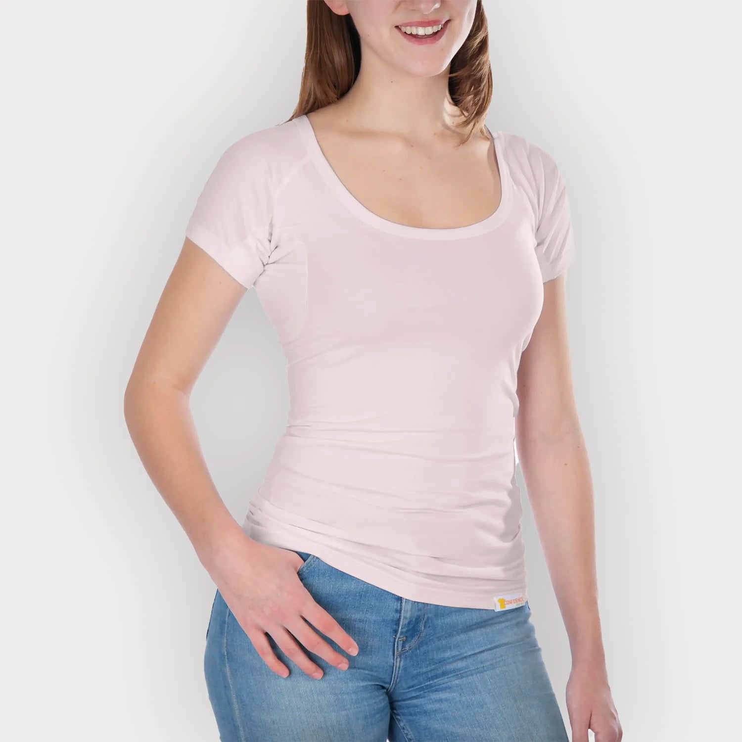 Vooraanzicht Studiofoto van vrouwelijk model met blauwe spijkerbroek en anti zweet shirt dames Ondershirts met korte mouwen aan van ConfidenceForAll in softpink op een lichtgrijze achtergrond