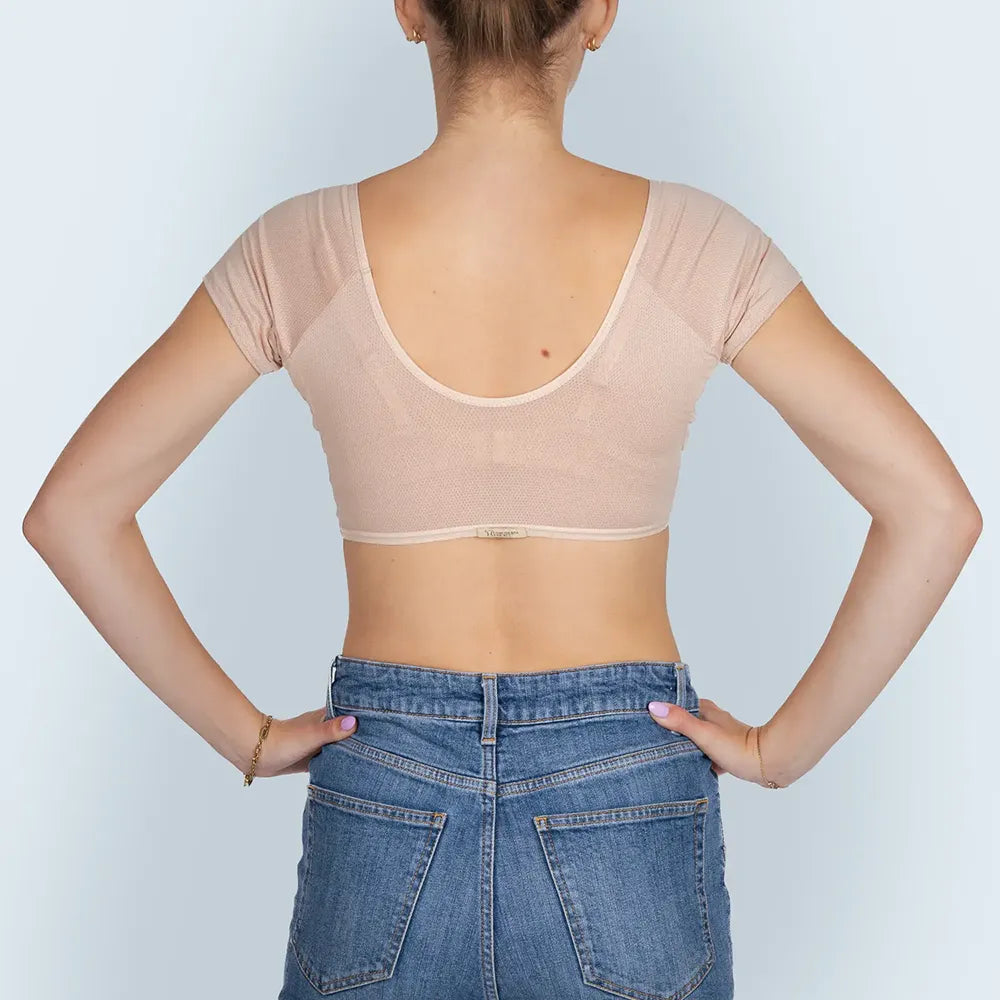 Vrouw model met BEIGE ANTI ZWEET COLLEGE TOP van ConfidenceForAll en blauwe spijkerbroek achteraanzicht in studio