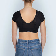 Vrouw model met ZWARTE ANTI ZWEET COLLEGE TOP van ConfidenceForAll en blauwe spijkerbroek achteraanzicht in studio