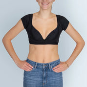 Vrouw model met ZWARTE ANTI ZWEET COLLEGE TOP van ConfidenceForAll en blauwe spijkerbroek vooraanzicht in studio