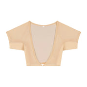 Flatlay-fotografie van de voorkant van een doorschijnende beige ConfidenceForAll DryDress-top met korte mouwen, voorzien van grote, zweetabsorberende, antibacteriële zweetpads met een clip aan de voorkant om hem vast te maken.