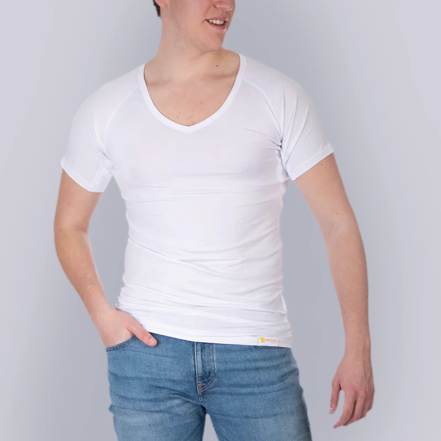 Studio produktfoto forfra af mandligt model med ANTI-SVED SKJORTE HERRE undershirt, V-hals, hvid, fra ConfidenceForAll og blå jeans