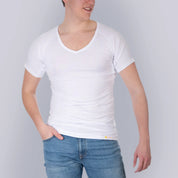 Studio produktfoto forfra af mandligt model med ANTI-SVED SKJORTE HERRE undershirt, V-hals, hvid, fra ConfidenceForAll og blå jeans