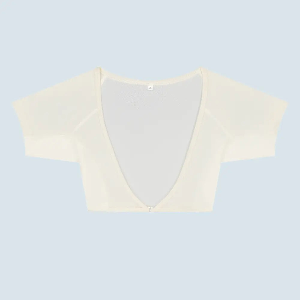 Flatlay-fotografie van de voorkant van een doorschijnende creme ConfidenceForAll DryDress-top met korte mouwen, voorzien van grote, zweetabsorberende, antibacteriële zweetpads met een clip aan de voorkant om hem vast te maken.