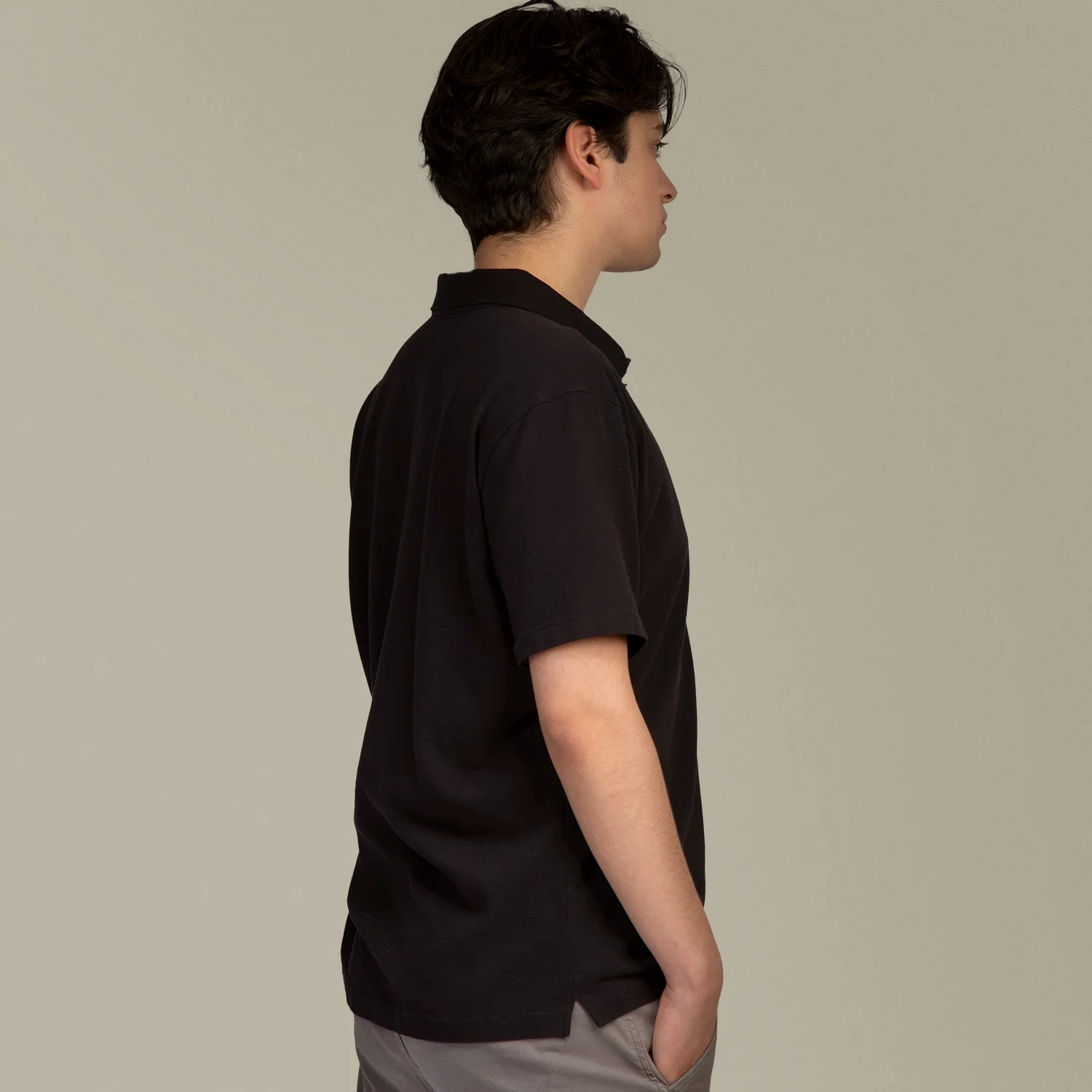 Studio Productfoto Mannelijk model met Anti Zweet Polo shirt Zwart van ConfidenceForAll zijkant en armen omlaag