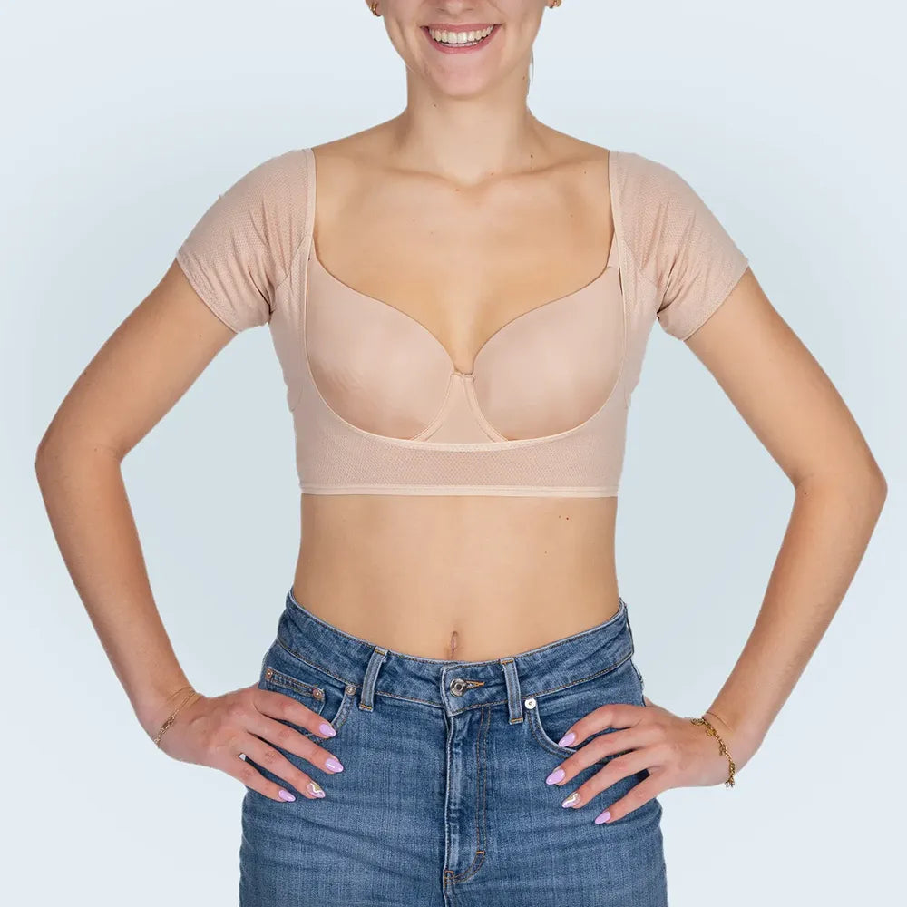 Vrouw model met BEIGE ANTI ZWEET COLLEGE TOP van ConfidenceForAll en blauwe spijkerbroek vooraanzicht in studio  