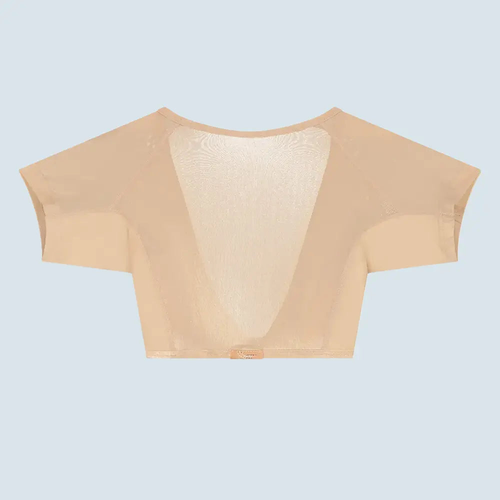 Flatlay-fotografie van de achterkant van een doorschijnende beige ConfidenceForAll DryDress-top met korte mouwen, met grote, zweetabsorberende, anti-transpirant en antibacteriële zweetpads met de label aan de achterkant en een clip aan de voorkant om hem vast te maken.