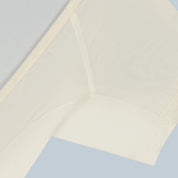 Flatlay detail otografie van een creme witte korte mouw en doorschijnende ConfidenceForAll DryDress-top met zweetabsorberende, anti-transpirant en antibacteriële zweetpads