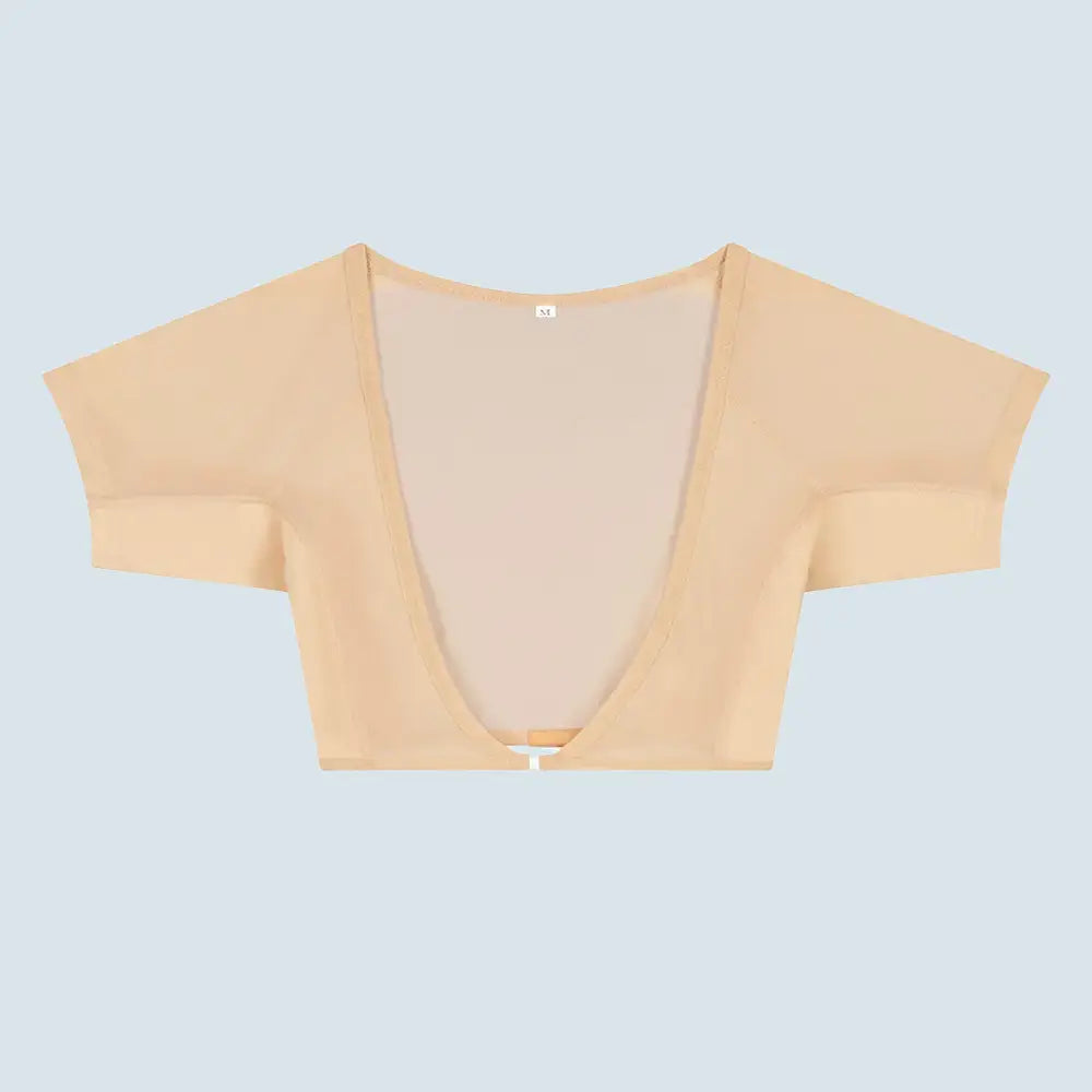 Flatlay-fotografie van de voorkant van een doorschijnende beige ConfidenceForAll DryDress-top met korte mouwen, voorzien van grote, zweetabsorberende, antibacteriële zweetpads met een clip aan de voorkant om hem vast te maken.