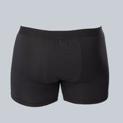 3D-studiofotografie van de achterkant van een zwarte, anti-transpirant, zweetbestendige boxershort van ConfidenceForAll met zweetpads op een effen grijsblauwe achtergrond.
