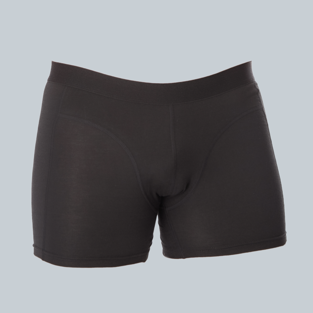 3D-studiofotografie van de voorkant van een zwarte, anti-transpirant, zweetbestendige boxershort van ConfidenceForAll met zweetpads op een effen grijsblauwe achtergrond.
