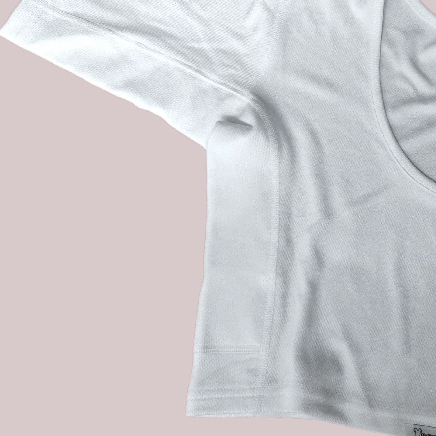 Flatlay Detailfoto van ConfidenceForAll Witte crop top met halve mouwen, zodat de zachte, ademende en snel drogende stoftextuur zichtbaar is